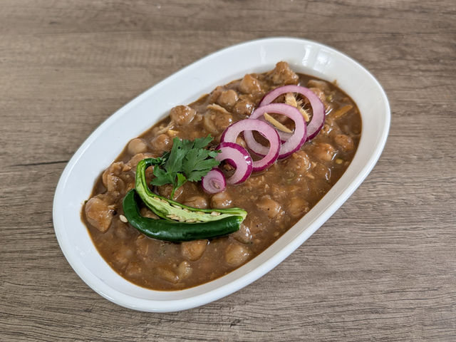 Chhole Bhature from Ruby's Rasoi, chickpea curry topped with red onion and a green chilli